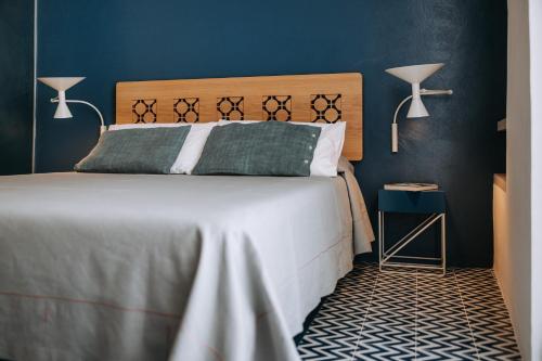 a bedroom with a large bed with blue walls at Infinito Bianco in Polignano a Mare