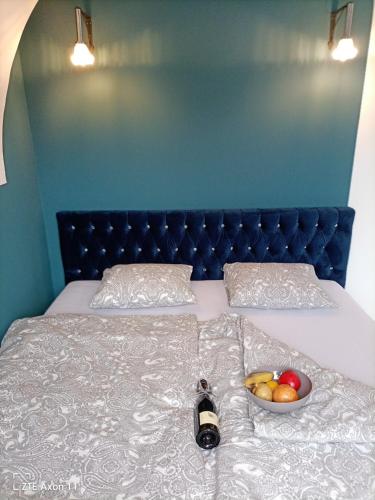 a bed with a bottle of wine and a bowl of fruit at Altstadtwohnungen "Grünberg 1D" & "Gmunden 3D mit Seeblick" im Zentrum von Gmunden in Gmunden