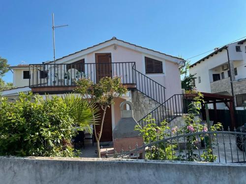 a house with a balcony and some plants at Apartments Pape in Malinska