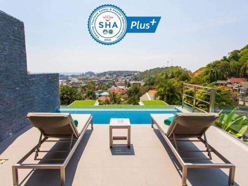 a villa with a swimming pool and two lounge chairs at Baan Saint-Tropez Seaview Villas Kata Beach in Kata Beach
