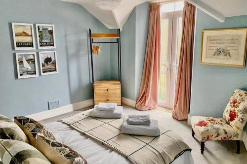 a bedroom with a large bed and a chair at The View in Bowness-on-Windermere