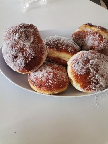 a plate of donuts with powdered sugar on it at B&B Villagiulia in Sogliano Cavour