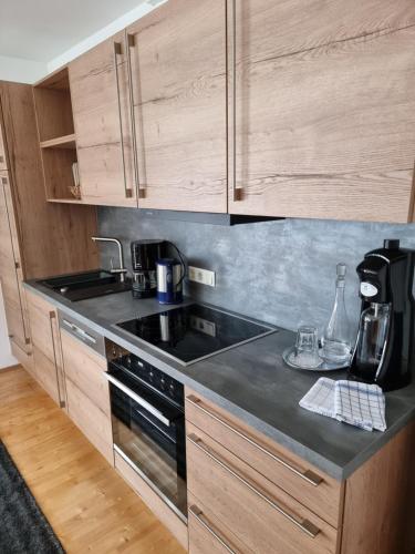 a kitchen with wooden cabinets and a stove top oven at Ferienlandhaus Höfer in Fulpmes