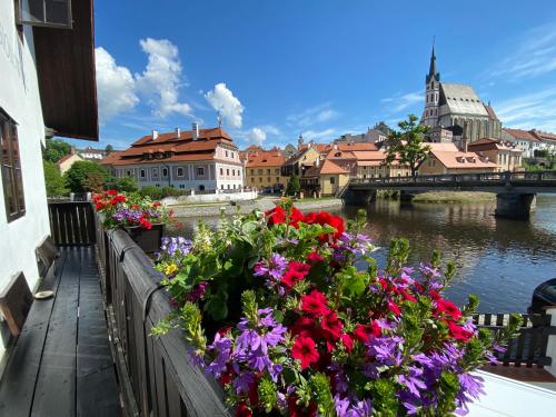 a bunch of flowers on a fence next to a river at Pension Wok in Český Krumlov