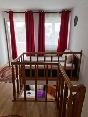 a bedroom with two bunk beds and red curtains at Deiada Guest House in Alba Iulia