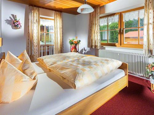 a bedroom with a large bed in a room with windows at Scheffaulehen Ferienwohnungen in Ramsau