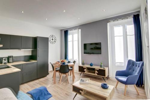 une cuisine et un salon avec des chaises bleues et une table dans l'établissement Palais Apartment, à Cannes
