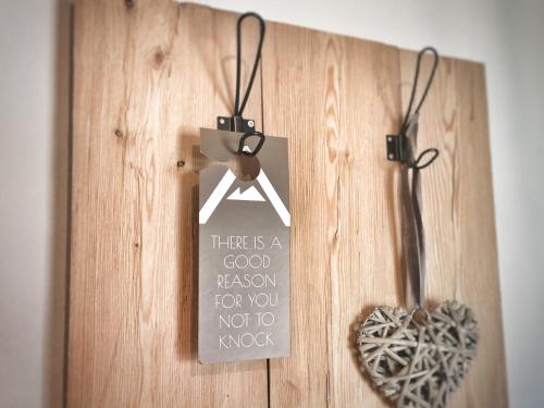 a sign on a wooden door with a heart on it at Gasthof Auwirt in Sankt Michael im Lungau