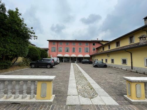 um grande edifício vermelho com carros estacionados num parque de estacionamento em Bes Hotel Bergamo Cologno al Serio em Cologno al Serio