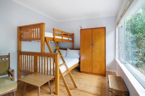 a bedroom with two bunk beds and a window at Beach Shack semi detached, 2 Min Walk to Beach-Lilly Pilly in Pearl Beach
