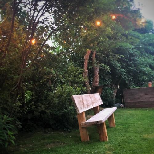 a wooden bench sitting in the grass in a yard at Gasthof Auwirt in Sankt Michael im Lungau