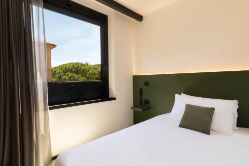Un dormitorio con una cama grande y una ventana en The City Hotel en Ancona