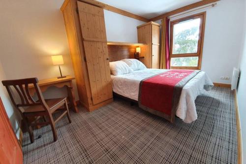 Un dormitorio con una cama y un escritorio y una ventana. en Arc 1950 Résidence 5* Sources de Marie 4/6 pers, en Arc 1950