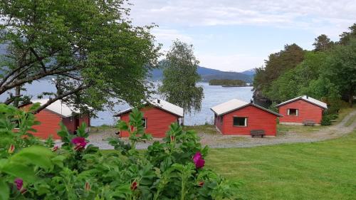 eine Gruppe von Gebäuden am Ufer eines Sees in der Unterkunft Teigen Leirstad, feriehus og hytter in Eikefjord