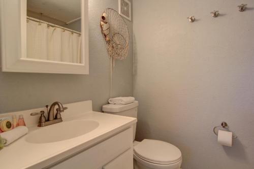 a bathroom with a toilet and a sink and a mirror at Jans Oasis 306BH in Port Aransas
