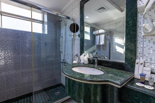 a bathroom with a sink and a shower at Faraj Almadina Hotel in Al Madinah