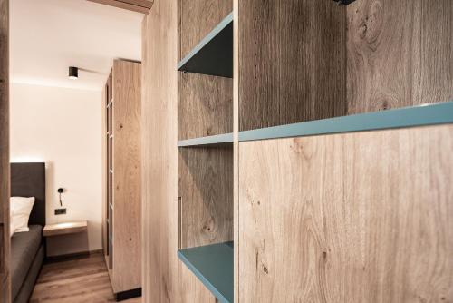 Cette chambre est dotée de murs et d'étagères en bois. dans l'établissement Mysciliar Apartment Tree I, à Alpe di Siusi