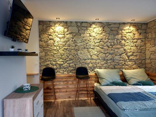 a bedroom with a bed and a stone wall at Kaland apartman 1 in Sátoraljaújhely