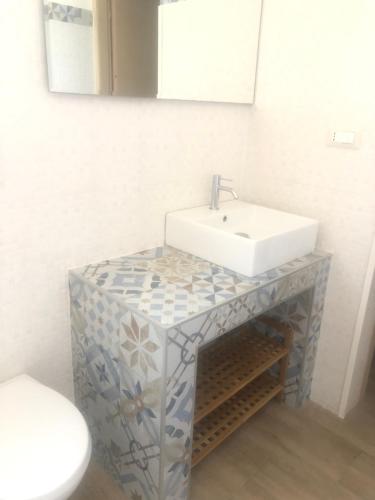 a bathroom with a sink and a toilet at Messapia Casa Vacanze in Ugento