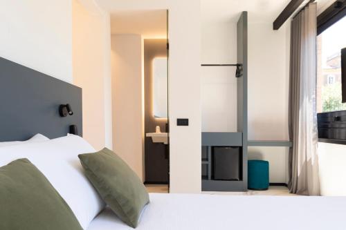 1 dormitorio con cama blanca y chimenea en The City Hotel, en Ancona