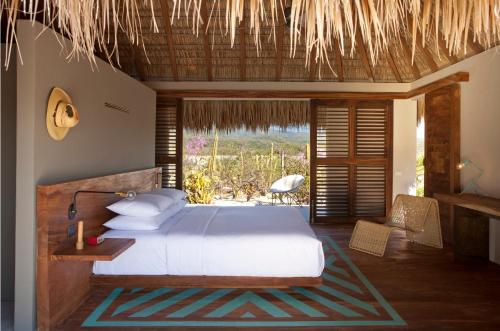 a bedroom with a bed and a view of the ocean at Hotel Escondido, Puerto Escondido, a Member of Design Hotels - Adults Only in Puerto Escondido