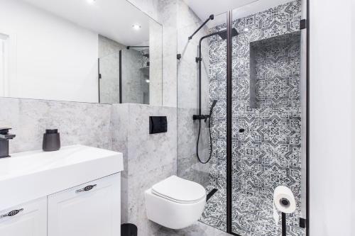 a bathroom with a shower with a toilet and a sink at Apartament Róża Wiatrów Giżycko/Wilkasy in Wilkasy