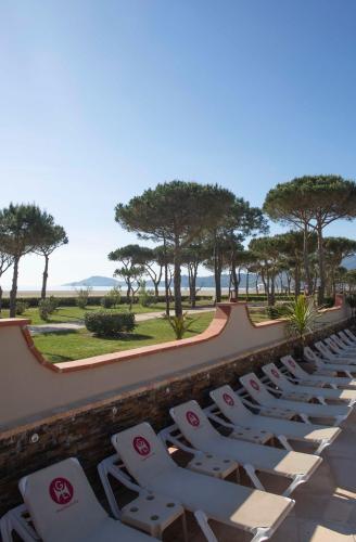 a row of chaise lounge chairs sitting on a patio at Grand Hôtel Du Lido in Argelès-sur-Mer