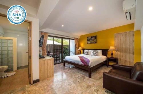 a bedroom with a bed and a couch in a room at Kamala Beachfront Apartment in Kamala Beach