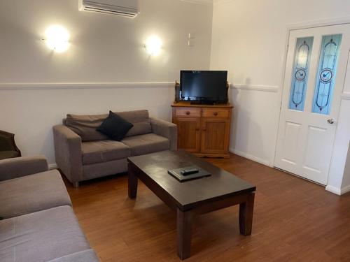 a living room with a couch and a coffee table at The Esplanade Motel in Lakes Entrance