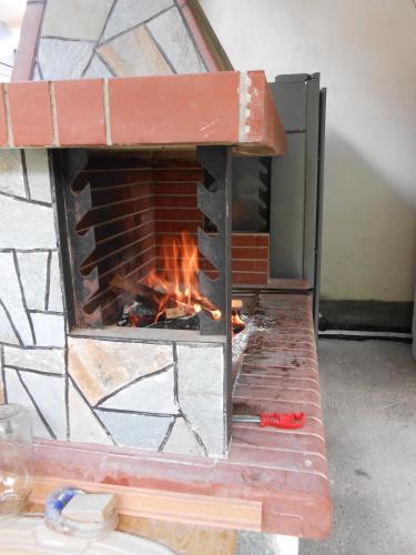 a brick oven with a fire in it at Armonia Hotel in Kato Loutraki