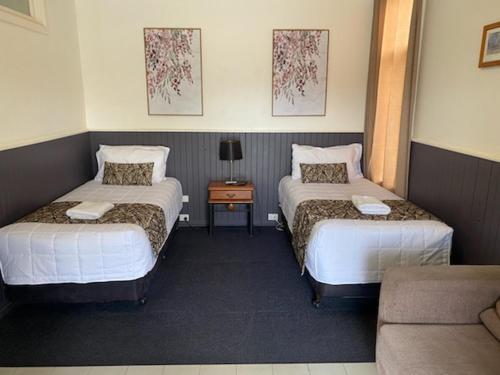 a hotel room with two beds and a couch at The Esplanade Motel in Lakes Entrance