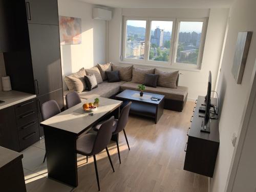 a living room with a couch and a table at Apartman Jasmin - Blizu Panonskih jezera i centra grada in Tuzla