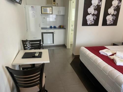 a room with a bed and a table and a kitchen at The Esplanade Motel in Lakes Entrance
