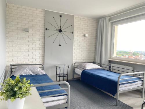 ソポトにあるApartament Sopot No. 1のベッド2台、壁掛け時計付きの客室です。