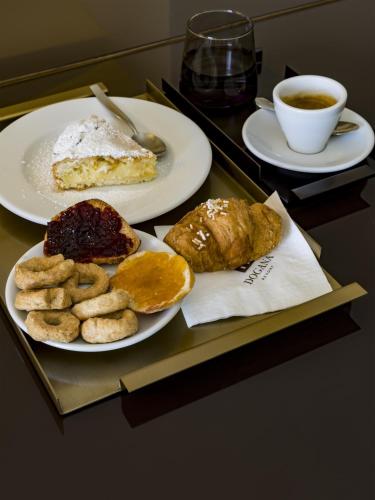 a table with two plates of pastries and a cup of coffee at DOGANA RESORT in Molfetta