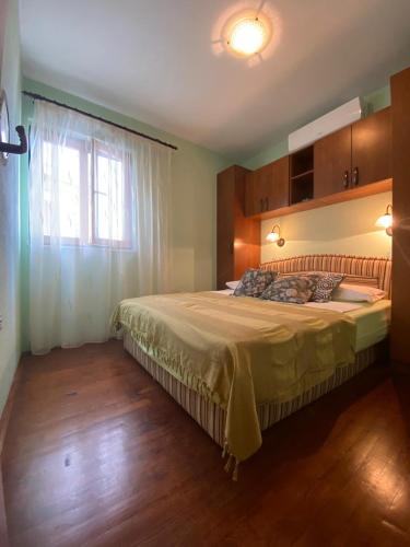 a bedroom with a large bed with a window at Apartments Linda in Drasnice