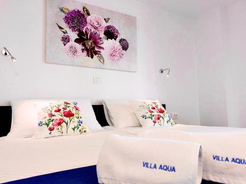 two beds in a hotel room with flowers on the wall at VILLA AQUA - Adults Only in Bol