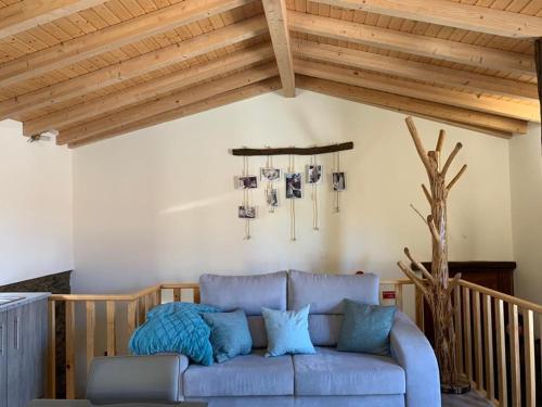 - un canapé bleu dans un salon avec des plafonds en bois dans l'établissement Casa das Estátuas, à Gondramaz