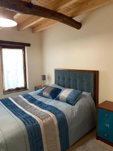 a bedroom with a large bed with a blue headboard at Casa das Estátuas in Gondramaz