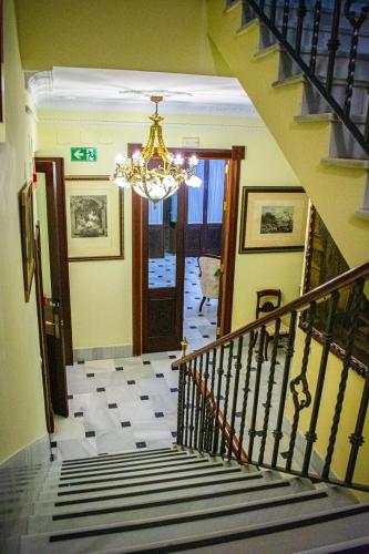a staircase in a house with a chandelier at Hotel Playa de Regla in Chipiona
