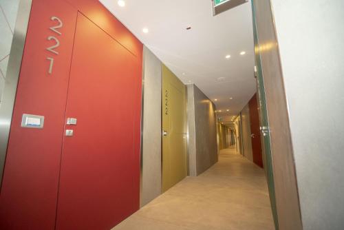 a corridor of an office with a red door at Hotel Malavoglia in Acitrezza