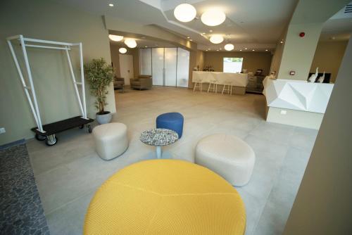 a large room with a yellow table and white chairs at Hotel Malavoglia in Acitrezza