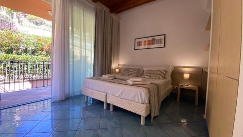 a bedroom with a bed and a balcony at Bellavista di Magarà in Cefalù