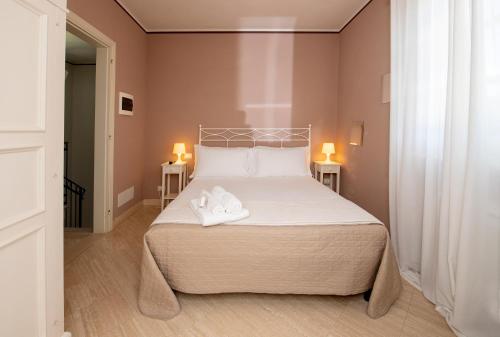 a bedroom with a bed with two white shoes on it at Relais Villa Isabel in Pietrasanta