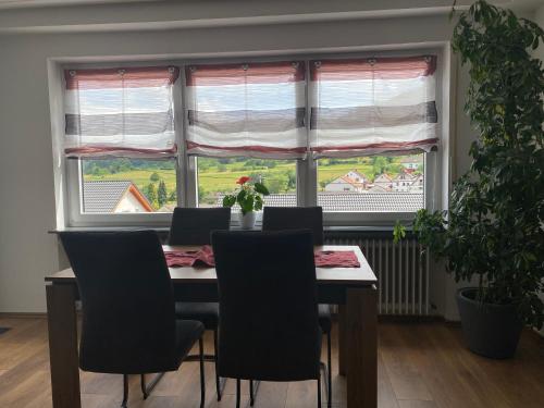 un tavolo da pranzo con sedie di fronte a una finestra di Ferienwohnung Nuß ad Annweiler am Trifels
