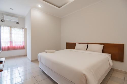 Un pat sau paturi într-o cameră la Rossan Villa Hotel near Kampus UPI Setiabudhi