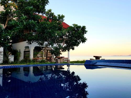 a house with a swimming pool in front of the ocean at Islandlife Bungalows in Thongsala