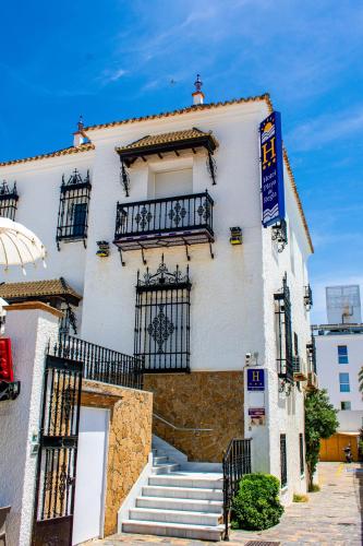 a white building with stairs and a balcony at Hotel Playa de Regla in Chipiona