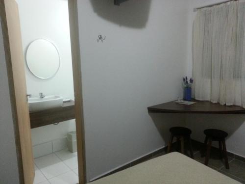 a bathroom with a sink and a vanity and a mirror at Rainbow Motel (Adult Only) in Itupeva