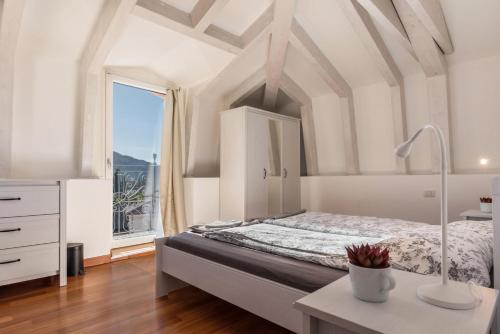 アルコにあるAppartamento Villa Principessaの白いベッドルーム(ベッド1台、窓付)
